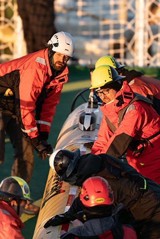 Senior Electronic Engineering Technician James McClure (left), ROV Pilot/Engineer Johann Voigtlander (right), and members of the expedition team preparing to launch an MBARI seafloor mapping AUV