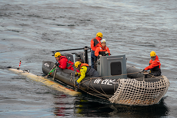 Dorado AUV Operations Engineer Jordan Caress (left) and Autonomous Systems Operations Engineer Tad Masek (second from left) recovering an MBARI mapping AUV