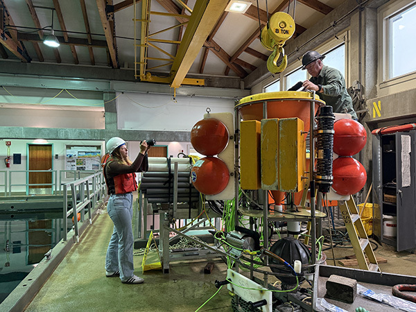 Science Communication Fellow Marike Pinsonneault (left) photographing ROV/MARS Manager Knute Brekke and the Sediment Event Sensor instrument-600